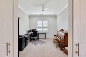 Home office with light colored carpet, ceiling fan, and crown molding