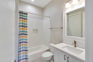 Full bathroom with shower / bath combination with curtain, toilet, and vanity