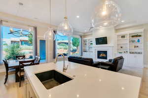 Kitchen with a large fireplace, sink, a healthy amount of sunlight, and decorative light fixtures