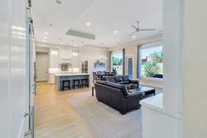 Living room with ceiling fan, light hardwood / wood-style flooring, and sink