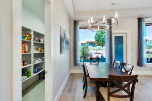 Dining area featuring an inviting chandelier and light wood-type flooring