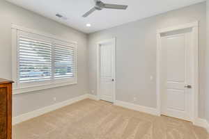 Unfurnished bedroom featuring light colored carpet and ceiling fan