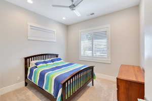 Carpeted bedroom featuring ceiling fan