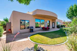 Rear view of house featuring a patio and a lawn