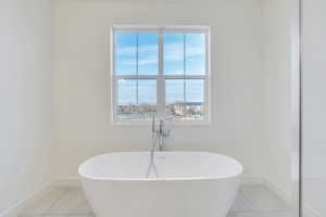 Bathroom featuring a washtub and tile patterned flooring