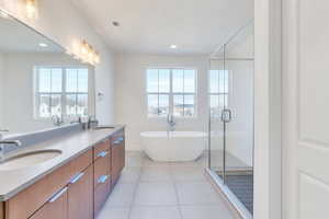 Bathroom with tile patterned flooring, vanity, and plus walk in shower