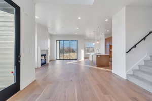 Unfurnished living room featuring sink and light hardwood / wood-style floors