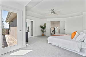 Bedroom with access to exterior, light colored carpet, ceiling fan, and lofted ceiling