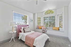 Bedroom with ceiling fan, carpet, and vaulted ceiling