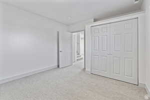 Unfurnished bedroom with a closet and light colored carpet