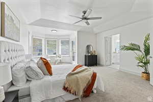 Carpeted bedroom featuring connected bathroom and ceiling fan