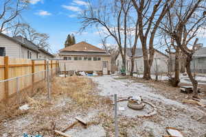 Snow covered rear of property featuring an outdoor fire pit and central AC