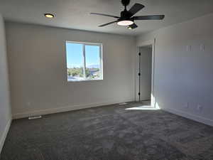 Carpeted spare room with ceiling fan