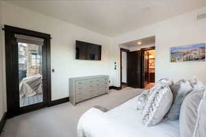 Bedroom with ensuite bathroom and light colored carpet