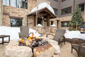 Snow covered patio with an outdoor fire pit