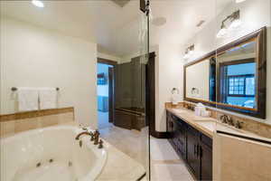 Bathroom featuring vanity and independent shower and bath