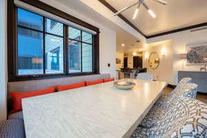 Dining room with a tray ceiling, hardwood / wood-style floors, a notable chandelier, and ornamental molding