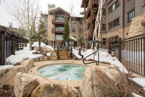 Snow covered pool featuring a community hot tub