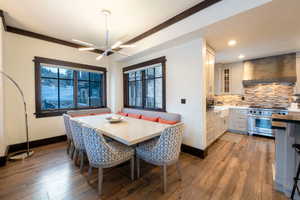 Dining area featuring hardwood / wood-style floors, breakfast area, ornamental molding, and a notable chandelier