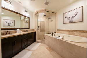 Bathroom with plus walk in shower, tile patterned flooring, and vanity