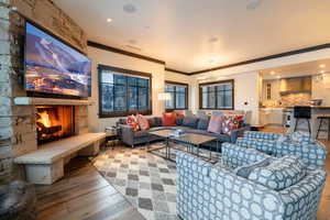 Living room featuring a fireplace, hardwood / wood-style flooring, and crown molding