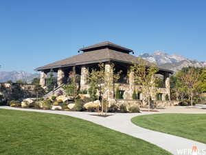 Surrounding community with a mountain view and a yard