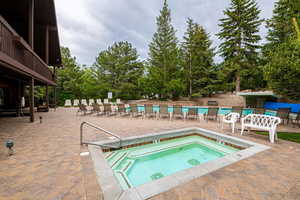 View of swimming pool with a patio and a hot tub