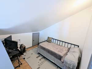 Bedroom featuring light hardwood / wood-style floors and vaulted ceiling