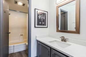 Full bathroom featuring vanity, shower / bath combination with curtain, toilet, and wood-type flooring