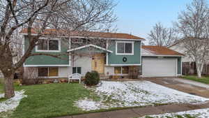 Split foyer home featuring a lawn and a garage