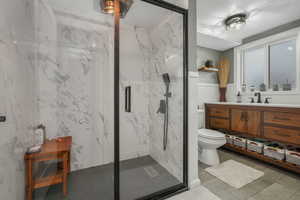 Bathroom featuring vanity, toilet, a shower with shower door, and a textured ceiling