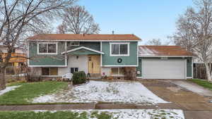 Bi-level home featuring a yard and a garage