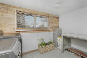 Laundry room featuring separate washer and dryer and wood walls