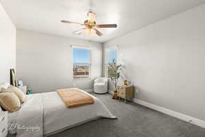 Carpeted bedroom featuring ceiling fan and a textured ceiling