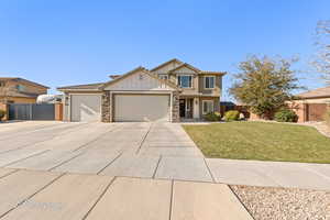 View of front of property featuring a garage and a front lawn