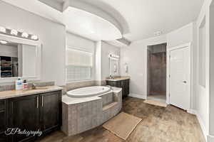 Bathroom featuring vanity, wood-type flooring, a textured ceiling, and shower with separate bathtub