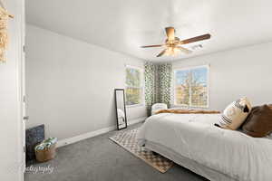 Bedroom with ceiling fan, carpet, and a textured ceiling