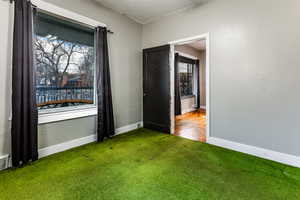 Unfurnished room featuring a textured ceiling and dark colored carpet