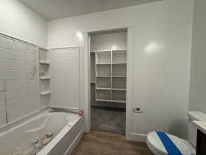 Full bathroom featuring vanity, toilet, wood finished floors, and a bathtub