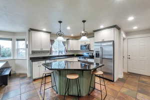 Kitchen with pendant lighting, sink, a kitchen bar, and stainless steel appliances