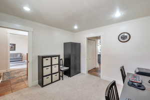 Home office featuring light carpet and crown molding