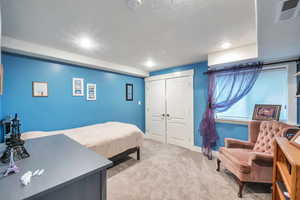 Bedroom featuring light colored carpet and a closet