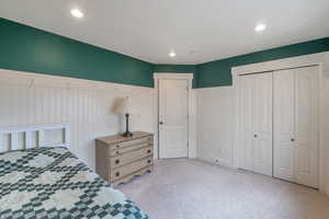 Bedroom featuring light colored carpet and a closet