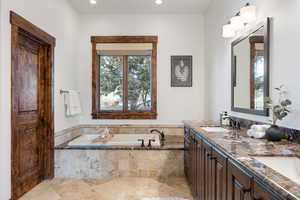 Bathroom featuring vanity and tiled tub