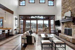 Living room with a fireplace, a towering ceiling, and hardwood / wood-style flooring