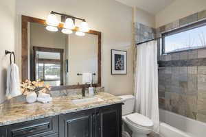 Full bathroom with vanity, toilet, and shower / bath combo with shower curtain