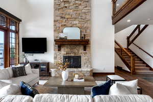 Living room with a stone fireplace and hardwood / wood-style floors