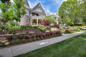 View of front of home featuring covered porch, a balcony, and a front lawn