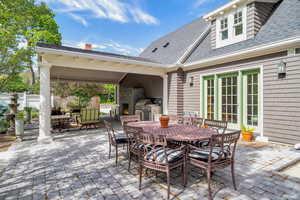 View of patio featuring a fireplace, an outdoor kitchen and a grill