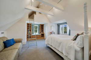 Carpeted bedroom featuring beam ceiling and high vaulted ceiling and loft.